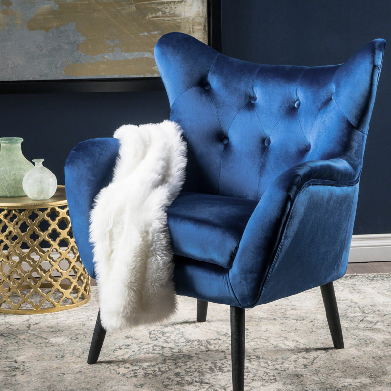 Fauteuil à oreilles bleu marine revêtu de velours de qualité, le style ajoute de l'élégance