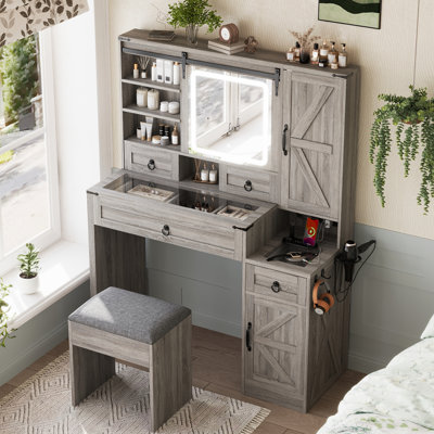 Bureau de coiffeuse avec miroir coulissant, lumières, plateau en verre et station de charge. Dans 4 tiroirs gris, 2 armoires un tabouret pour le look de chambre à coucher contemporain
