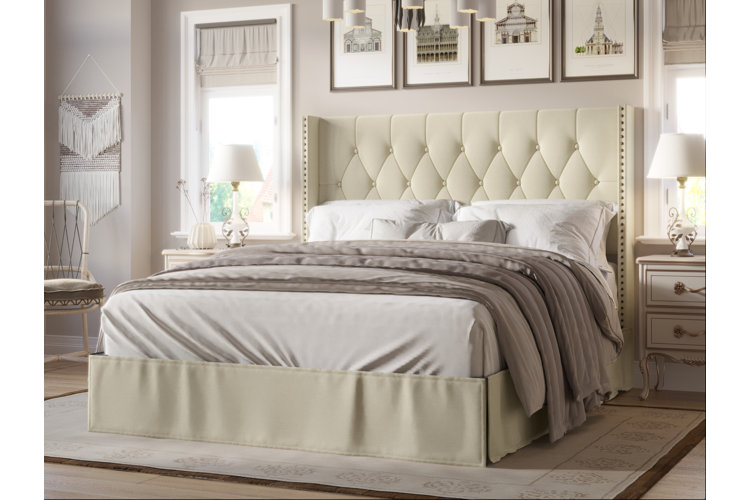 transitional style bedroom with ivory upholstered bed frame and neutral furnishings