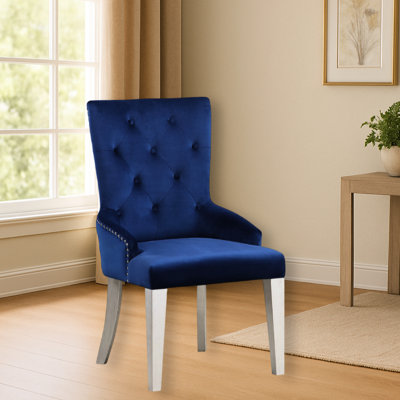 Fauteuil de salle à manger moderne en tissu bleu luxueux avec dossier capitonné et pieds fuselés en bois. Siège rembourré et tablier.