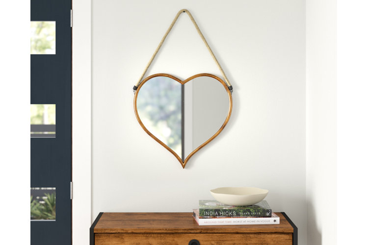 Heart-shaped mirror hanging on a wall next to the blue front door