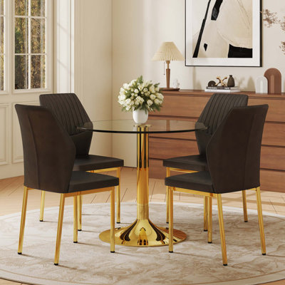Une table de salle à manger ronde en verre trempé transparent de 35 po, jumelée à 4 chaises de salle à manger à haute résilience avec pieds en métal