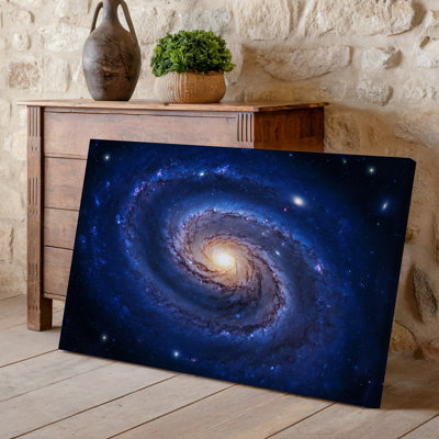 Toile, superbe galaxie en spirale posée sur un fond velouté profond de l'espace présentant des teintes vibrantes de bleu et de mauve
