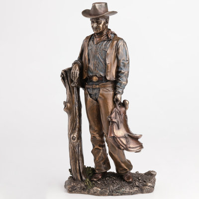 Cowboy de 13,39 po de hauteur tenant une selle contre un poteau de clôture, en résine de polyester