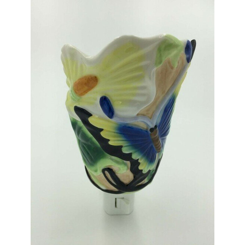 Papillon bleu sur une veilleuse en forme de bouton floral