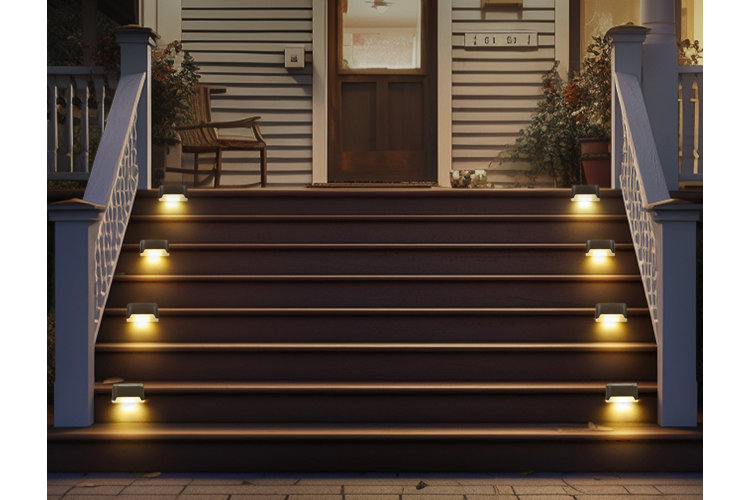 A set of stairs with built in lights that help illuminate each step up to the front porch.