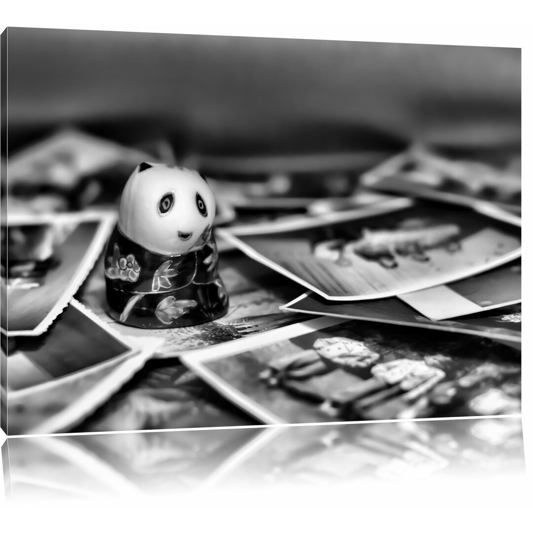 Leinwandbild Panda Figur zwischen Fotografien in Monochrom