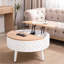 Table basse ronde à plateau relevable avec rangement caché et base sculptée - Bois naturel et blanc