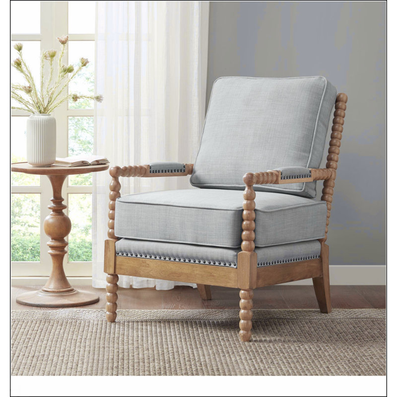Fauteuil en chêne clair clair et polyester avec bordure cloutée et quatre pieds robustes, parfait pour la lecture et la détente