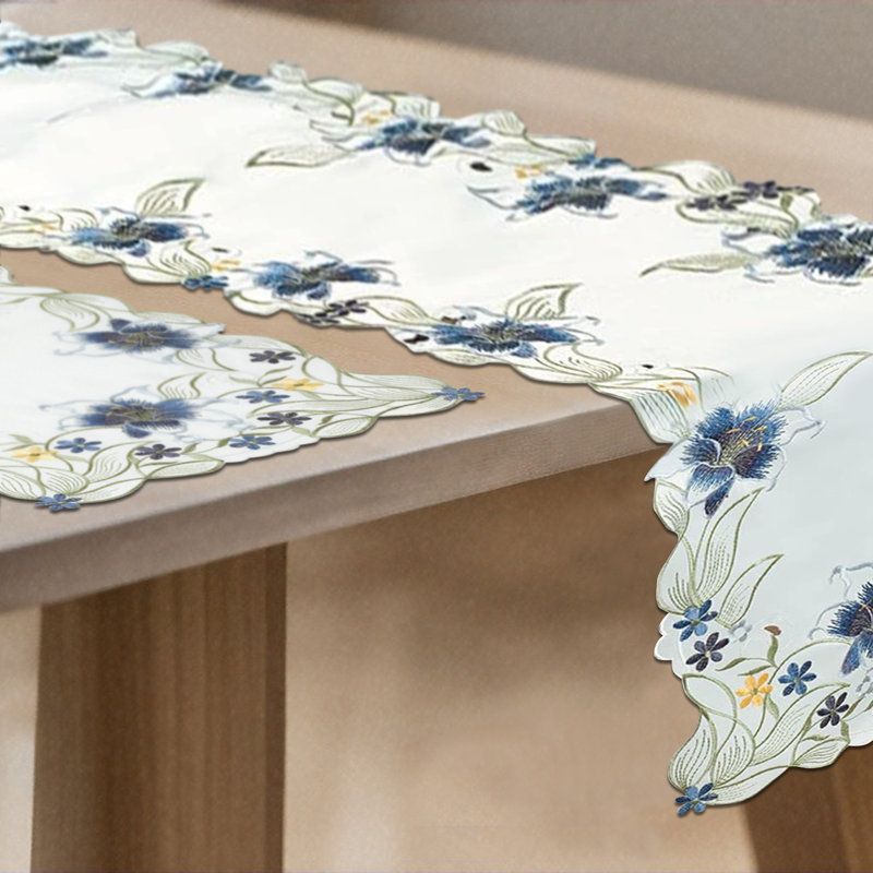 Chemin de table bleu Anner avec broderies et découpes