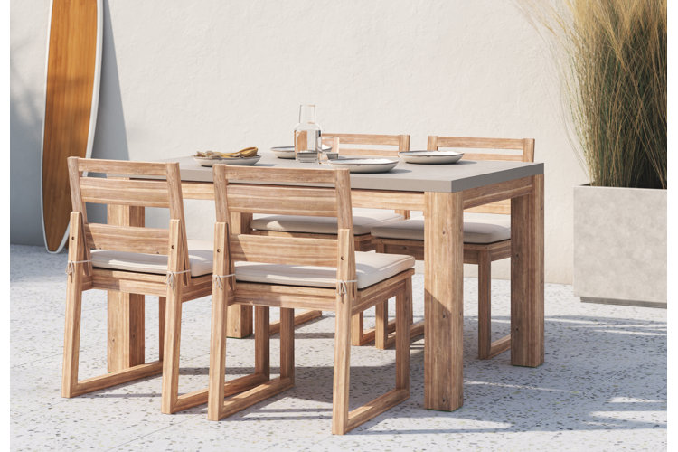 Outdoor patio area with wooden dining table and chairs.