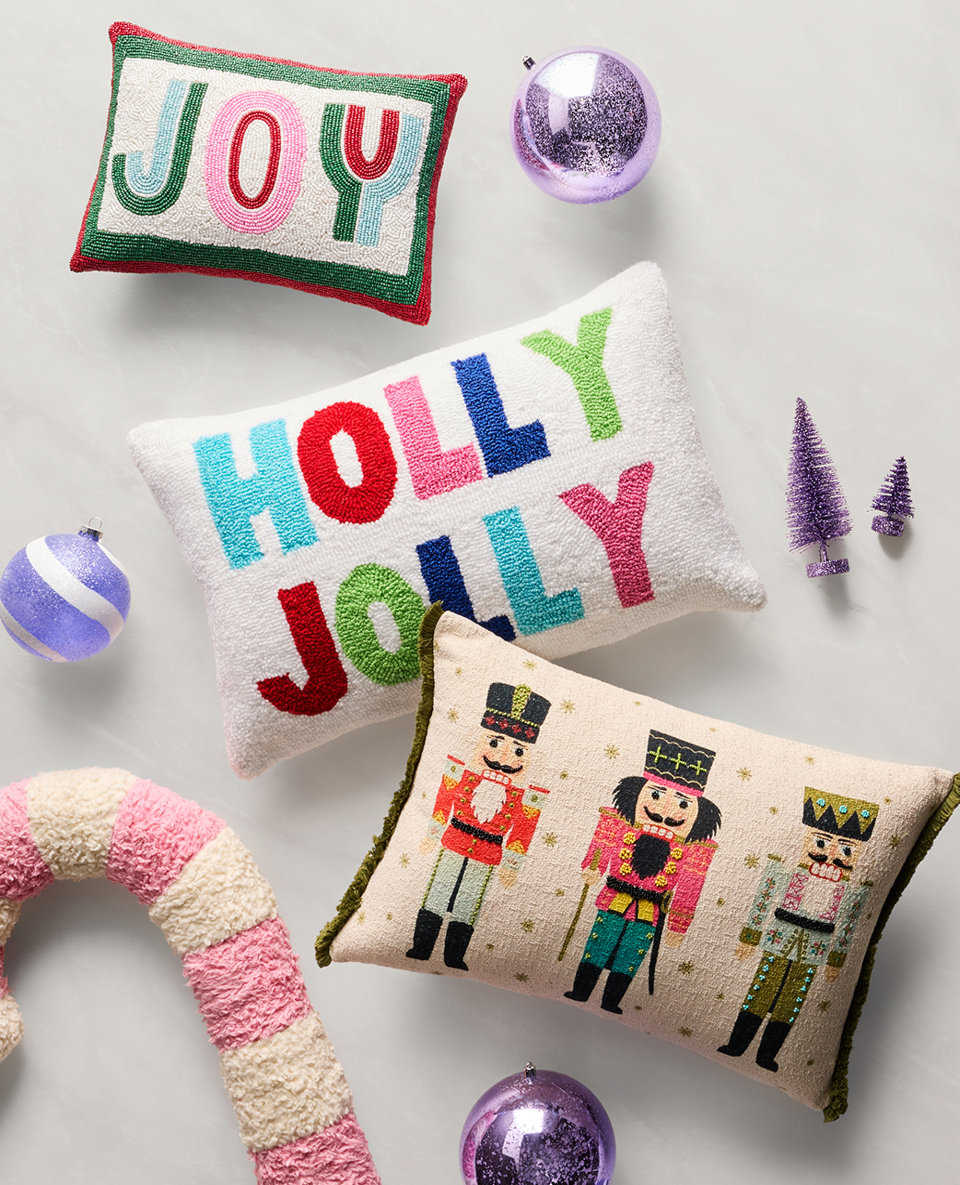 Three throw pillows that read, "Joy," "Holly Jolly," and feature nutcrackers.