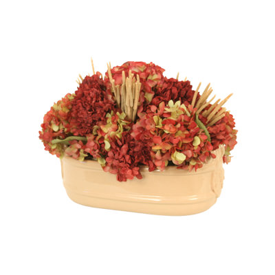 Hortensia vert bourgogne mélangé avec du millet séché et un feuillage dans un pot beige