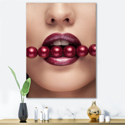 Femme avec des perles rouges dans la bouche dans une pose sensuelle - photographie sur toile