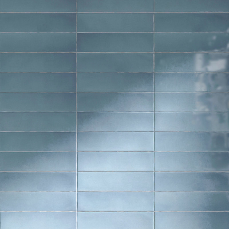 Ceramic subway wall tile in a glossy ocean blue finish with a stacked grid pattern.