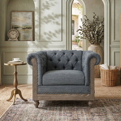Fauteuil club avec accoudoirs en volute et ornements cloutés