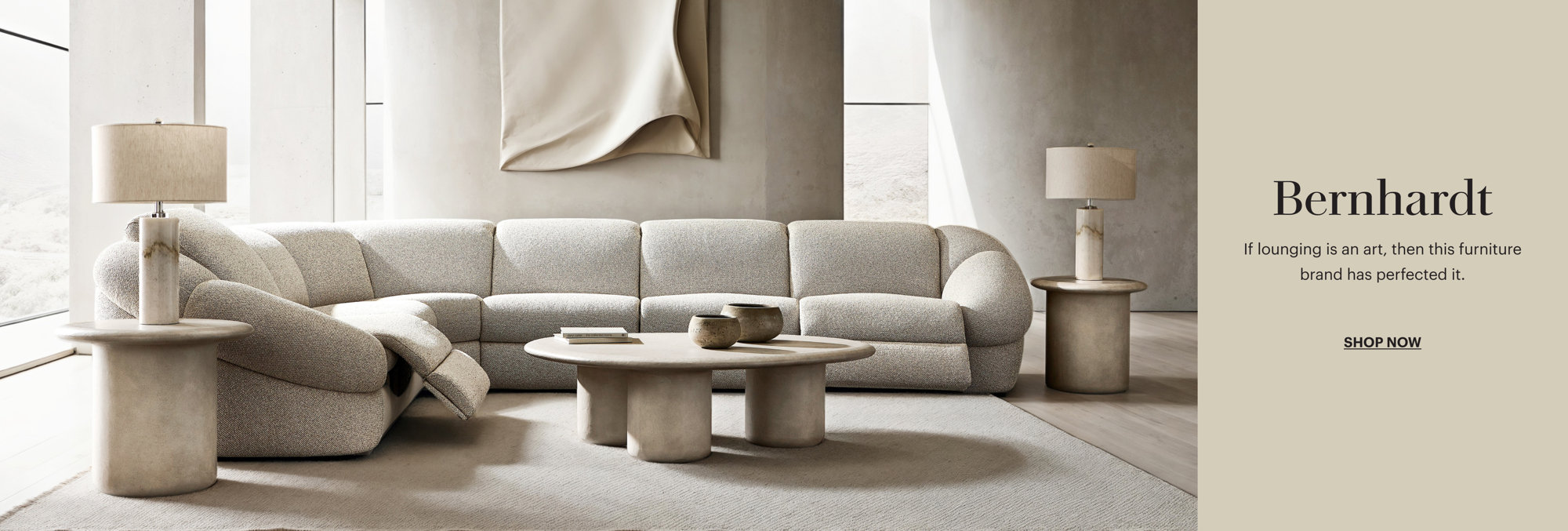Refine how you recline with Bernhardt furniture featuring a modern neutral living room with a curved sofa, textured wall art, and minimalist decor, Shop Now.