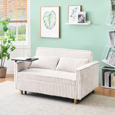Canapé convertible en velours côtelé beige avec bureau amovible, ajoutant de la polyvalence à votre espace de vie. Élégante table basse, pièce raffinée.