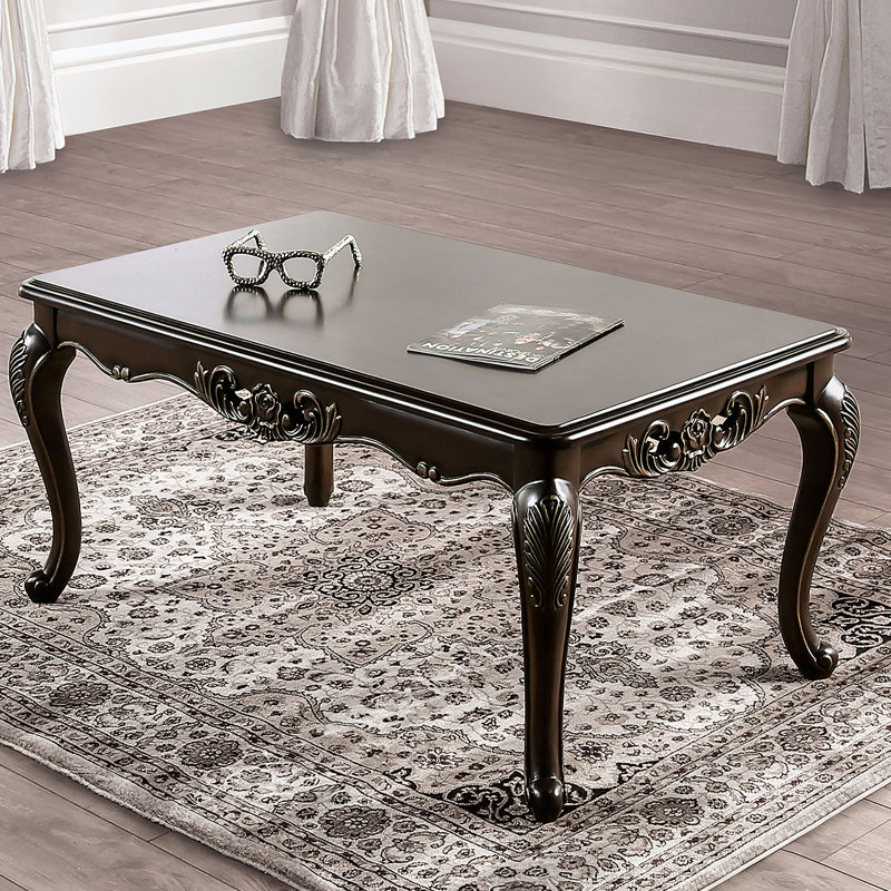 Table basse de style traditionnel avec des pieds courbés, une conception sculptée et une structure en bois massif avec une finition Java riche