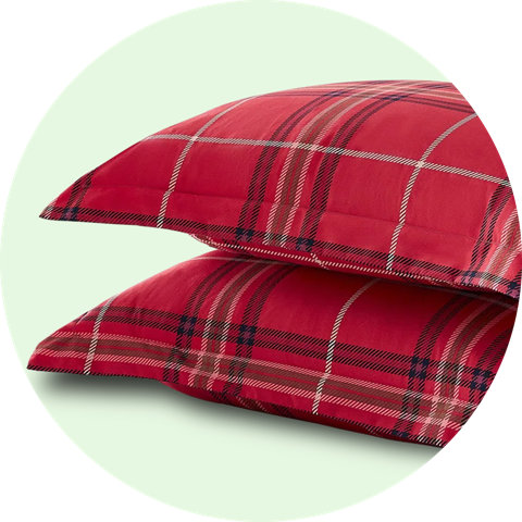 Two stacked red plaid pillow shams.