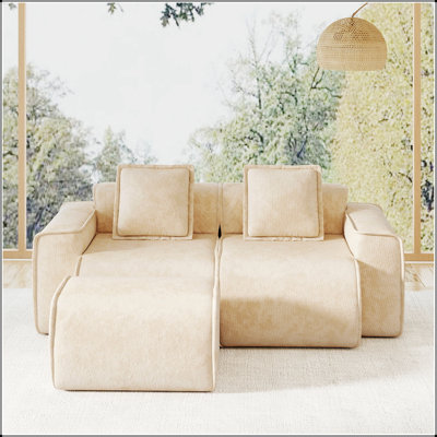 Canapé d'angle modulaire deux places en velours avec pouf amovible et finitions passepoilées.