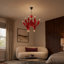 Lustre contemporain en verre rouge avec bras sculpturaux incurvés et accents chromés