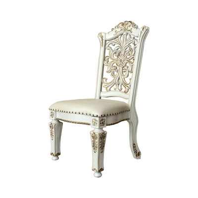 De 2 chaises sans accoudoirs - Cuir synthétique et finition perle antique, Coussin de siège rembourré avec garniture cloutée, Moulure florale découpée en bois, Tablier de garniture, Pieds fuselés, Capacité de poids de 220 lb, l 23 po, 20 po