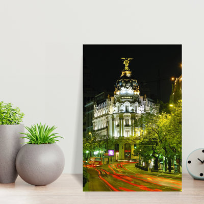 Metropolis Building At Night And Light Trails On Street Madrid Spain by Miles Ertman - Wrapped Canvas Print