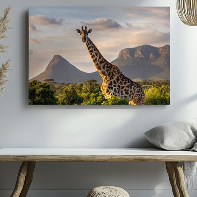 Toile, une girafe majestueuse se dresse contre un paysage vert éclatant, art mural
