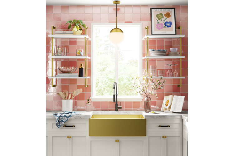 Modern kitchen with pink glossy backsplash tiles and a golden sink.
