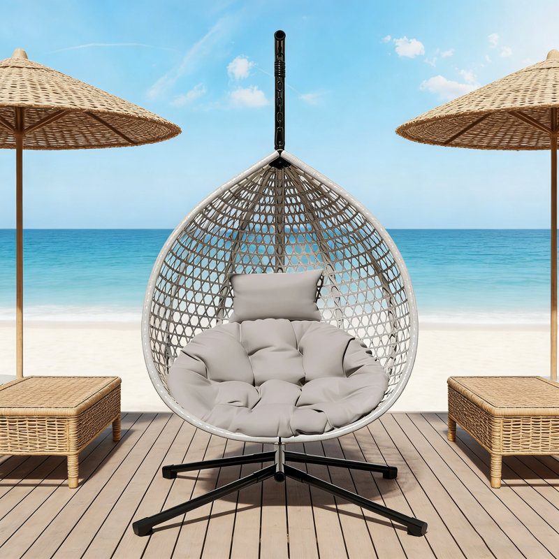 Chaise hamac robuste avec support, tissage en rotin durable et coussin amovible pour une utilisation intérieure et extérieure.