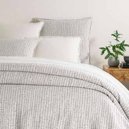 Bed with gray dotted pattern bedding.