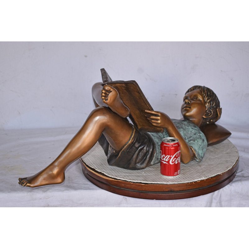 Kid On A Pillow Reading A Book Bronze Statue - Size: 32"L X 13"W X 12"H.