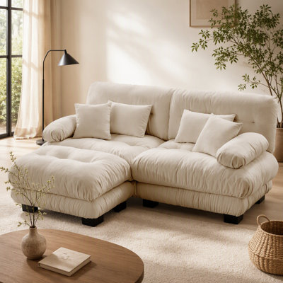 Luxueux canapé en chenille pour le salon avec plusieurs coussins et repose-pieds convertible, pour plus de confort et de style.
