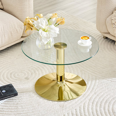 Table basse ronde en verre trempé. 17,7 pouces de haut, soutenu par une base en métal doré, avec un bord de luxe léger.