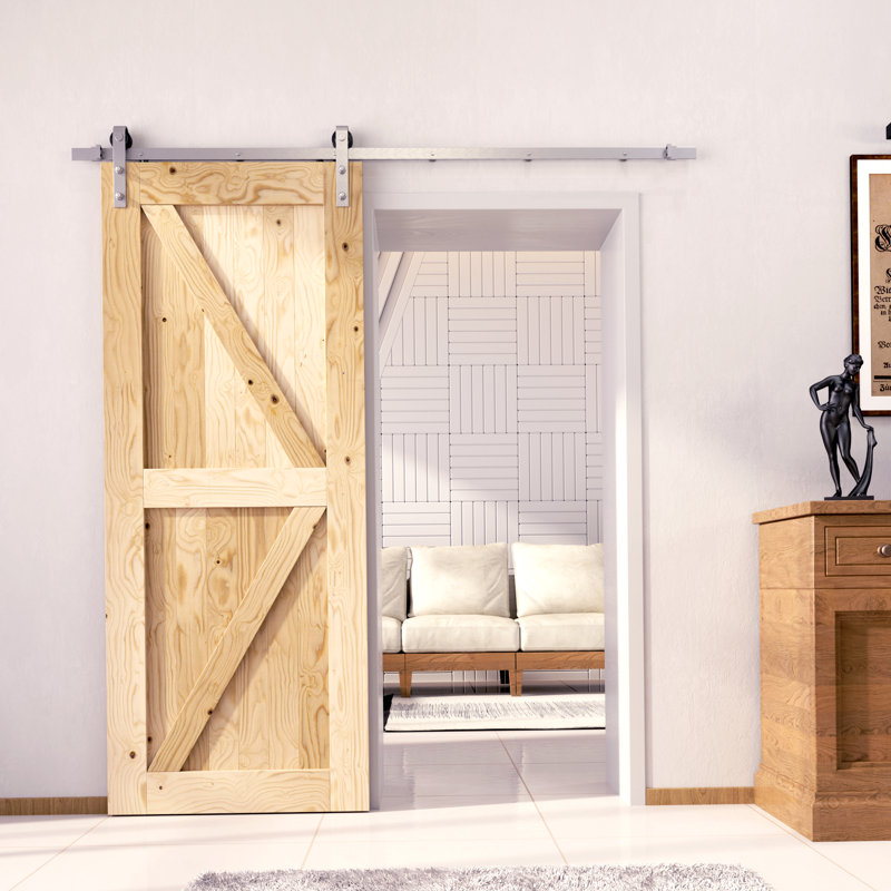 Une porte de grange en bois de pin massif non fini / non assemblé avec une quincaillerie d'installation en nickel brossé