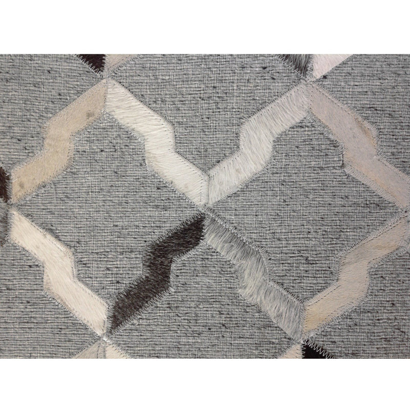 Tapis gris en peau de vache à motif géométrique