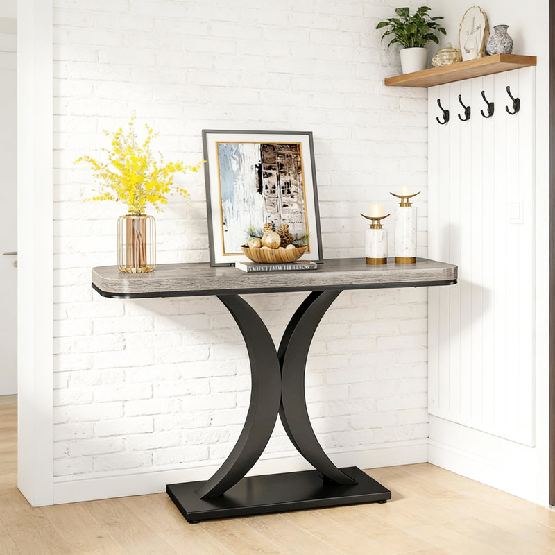 Table d'entrée de style industriel moderne, console compacte avec piètement en bois épais et incurvé, idéale pour le salon, le bureau ou le couloir. Longueur : 100 cm (39,4 po). Plateau design et lignes géométriques allongées.
