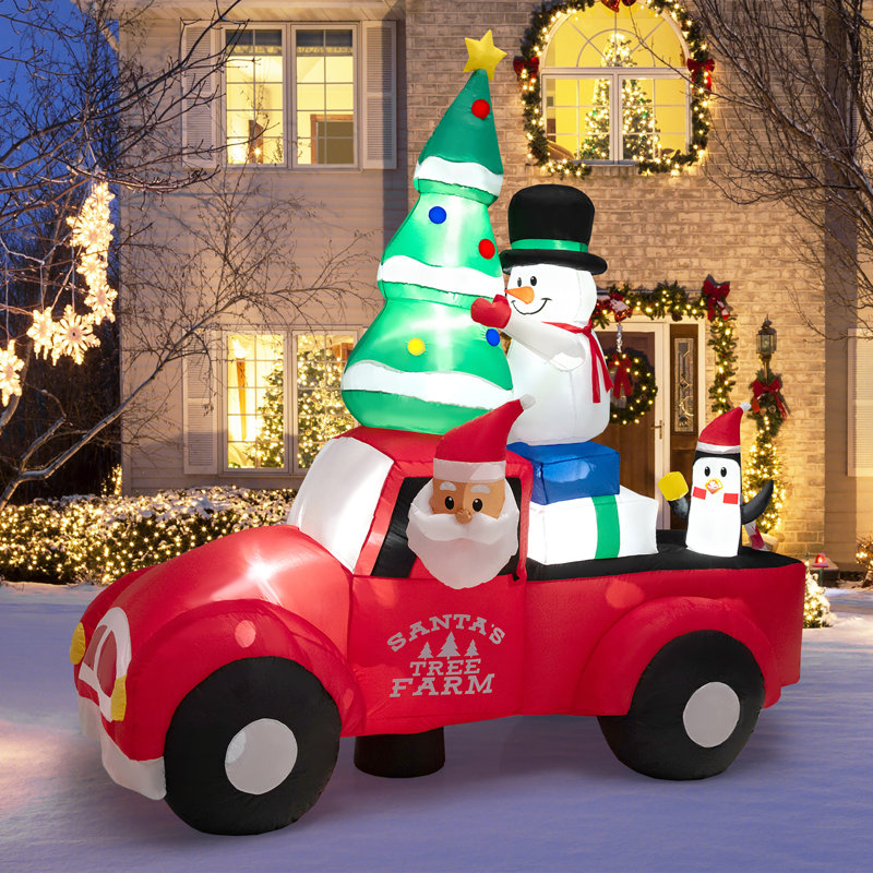 Grand père Noël conduisant une voiture gonflable