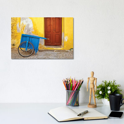 Greece, Rhodes. House With Blue Cart In Front. by Jaynes Gallery - Wrapped Canvas Print
