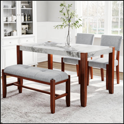Ensemble de salle à manger moderne quatre pièces comprenant une table d'aspect marbre, des chaises rembourrées et un banc avec pieds en bois massif.