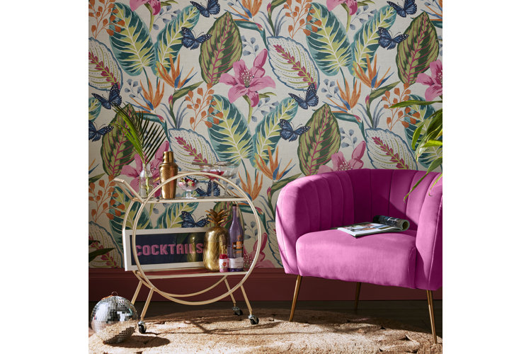 Tropical botanical wallpaper, a pink accent chair and gold bar cart.