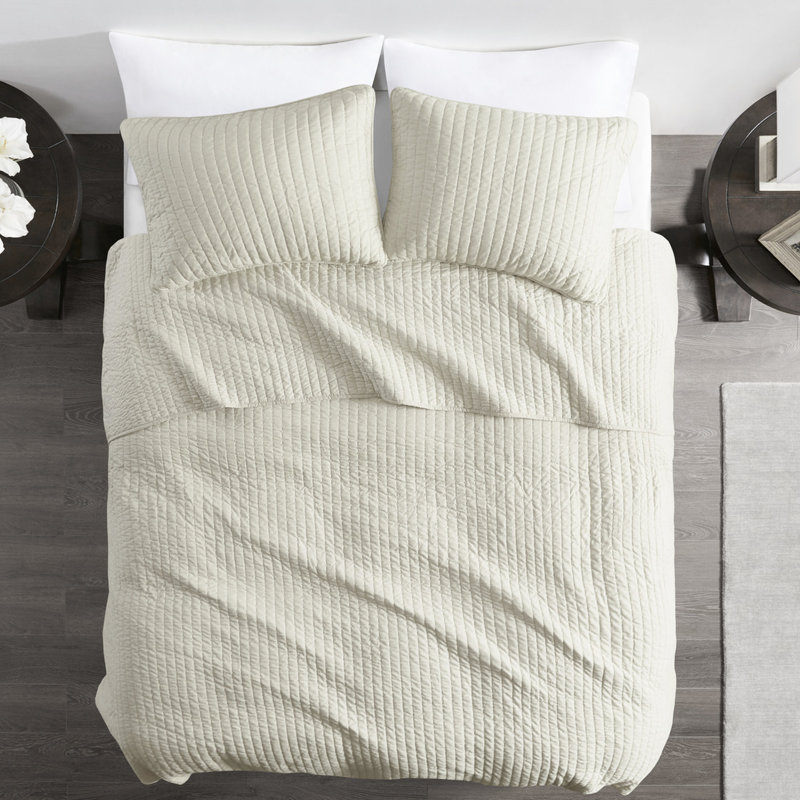 Couette 3 pièces couleur crème, format grand lit/queen, en microfibre et coton réversible pour des nuits paisibles et un confort optimal. Garnie de coton.