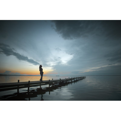 Silhouette of woman on lakeside