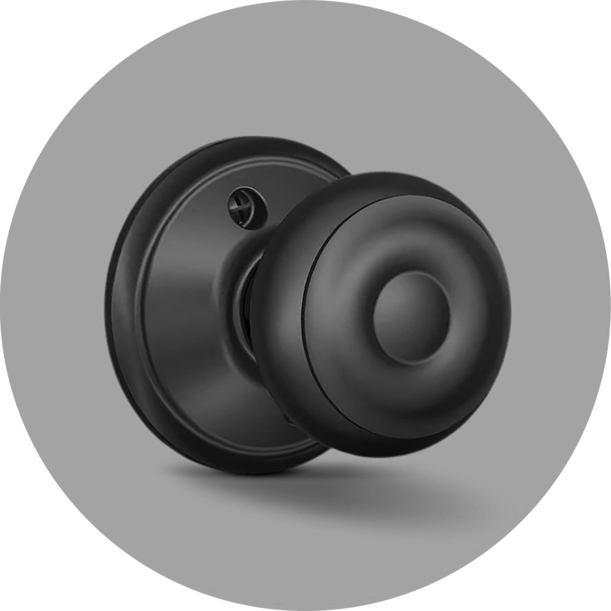 Matte black round door knob with a circular rosette against a gray background.