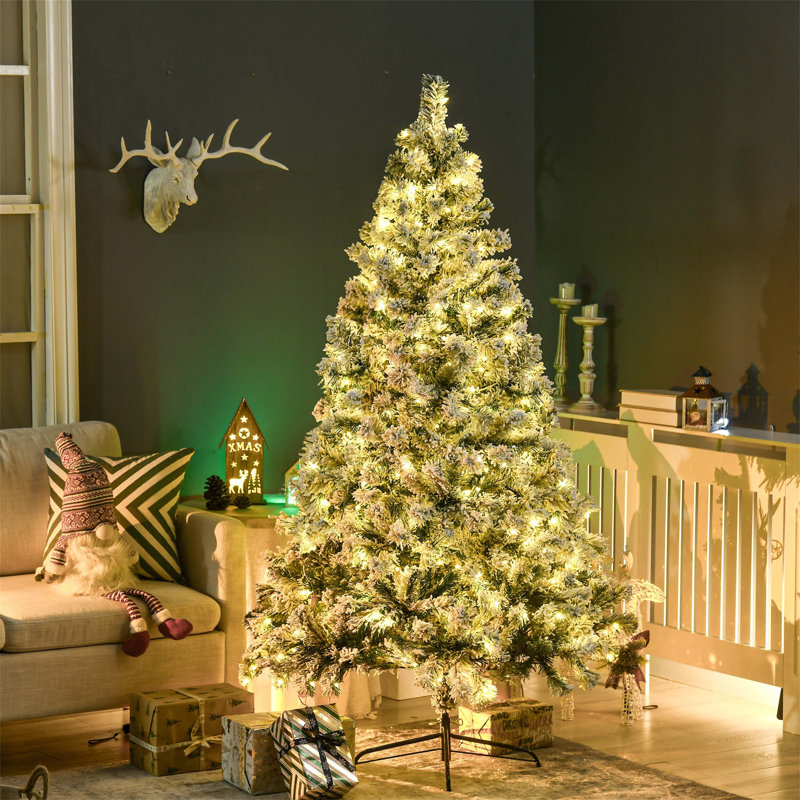 Arbre de Noël artificiel pré-éclairé pour décoration des Fêtes avec branches enneigées, lumières DEL et base en acier, créant une atmosphère festive