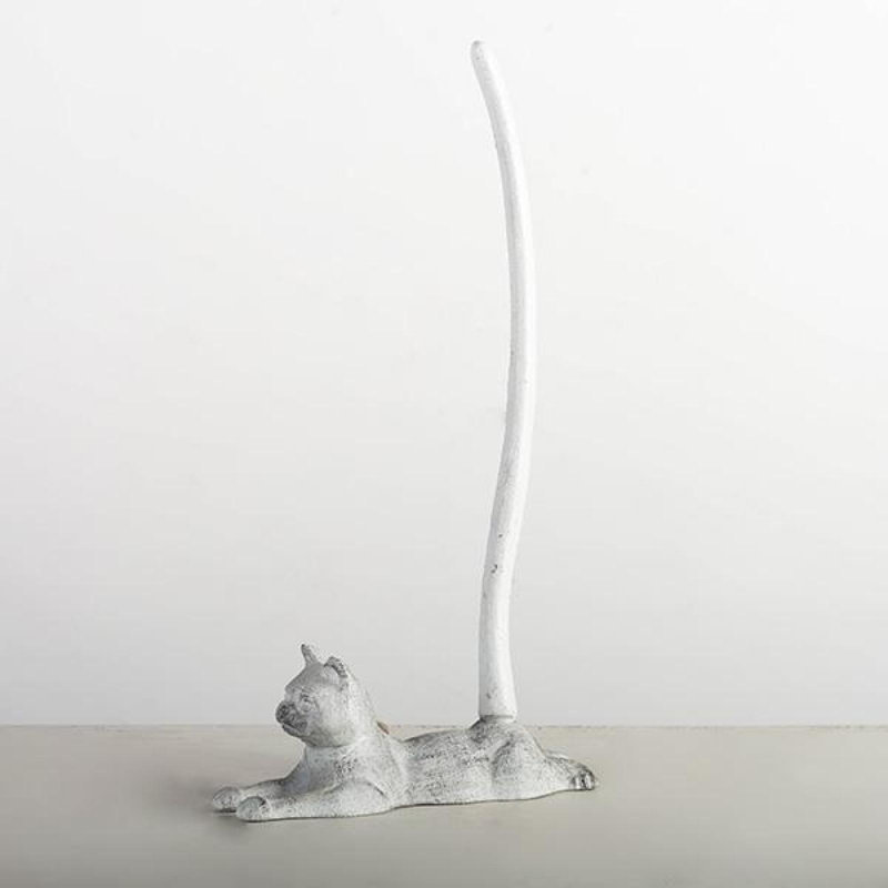 Chat antique blanc allongé avec porte-serviette à longue queue