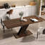 Cet ensemble de tables et chaises de salle à manger présente un design moderne et élégant, qui rehausse son esthétique. La table est dotée d'un piètement robuste en forme de X décalé, qui met en valeur sa beauté géométrique.