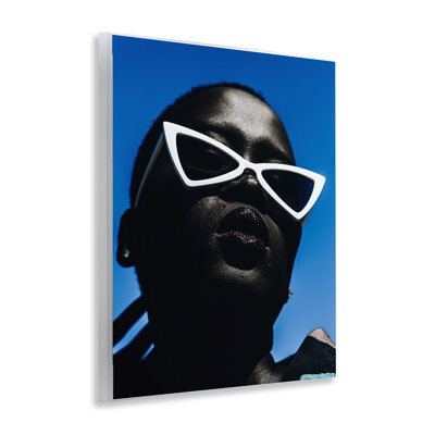 Élégantes lunettes de soleil sur une plaque murale bleue par Oladimeji Odunsi