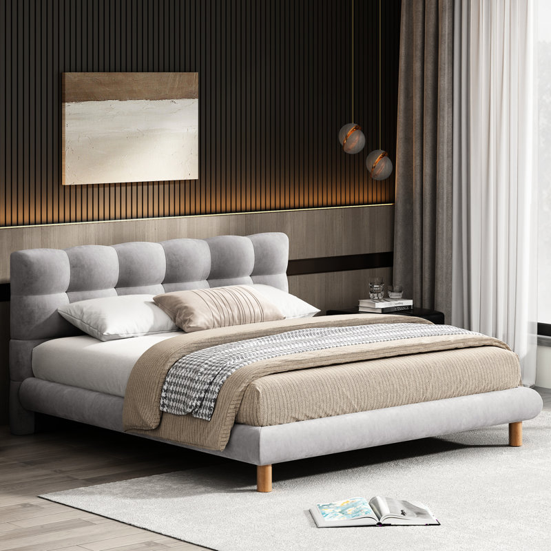 Confortable lit double gris avec tête de lit distinctive en forme de biscuit et structure stable en chenille